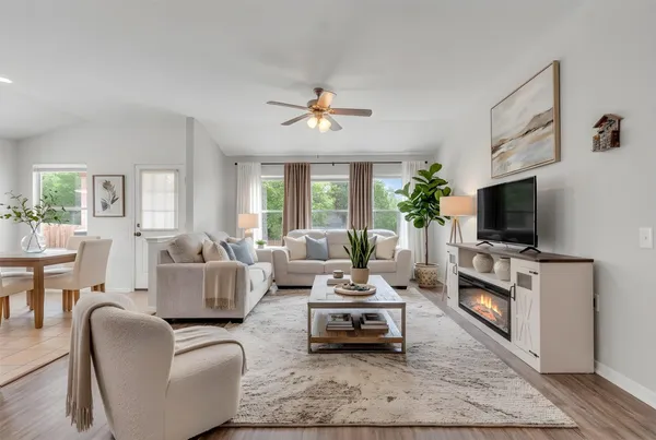 a living room with furniture a flat screen tv and a fireplace