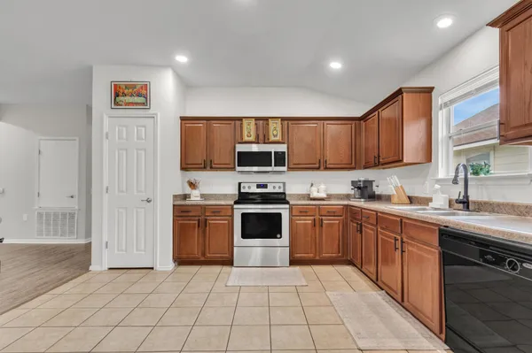 a kitchen with a sink refrigerator and cabinets