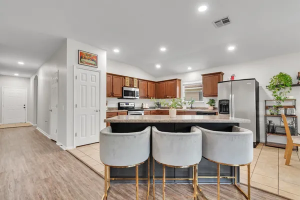 a kitchen with stainless steel appliances granite countertop a stove top oven a sink and dishwasher