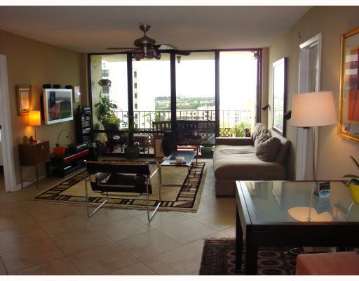 336 Golfview Road, Unit 1008 North Palm Beach, FL 33408 - Photo 2 of 5 a living room with furniture and a flat screen tv