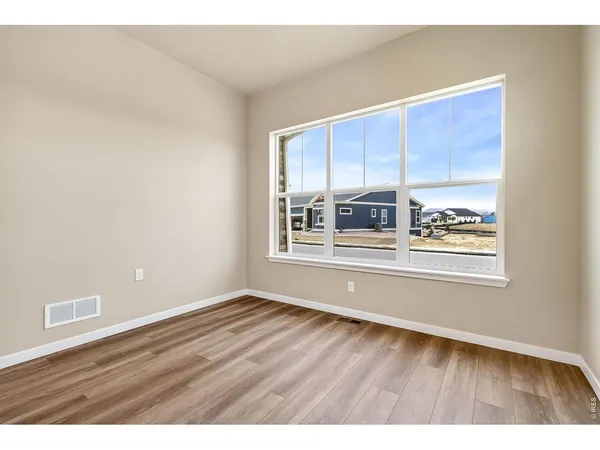 an empty room with wooden floor and closet