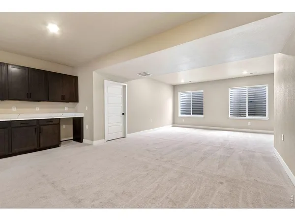 a spacious bedroom with a bed and a flat screen tv