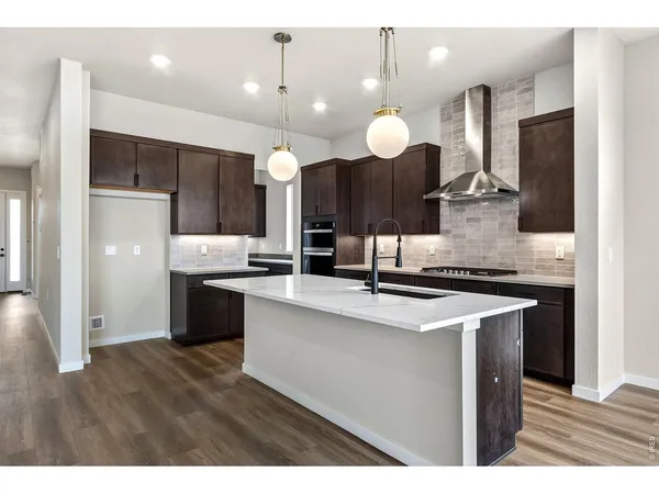 a kitchen with kitchen island a sink stainless steel appliances and cabinets