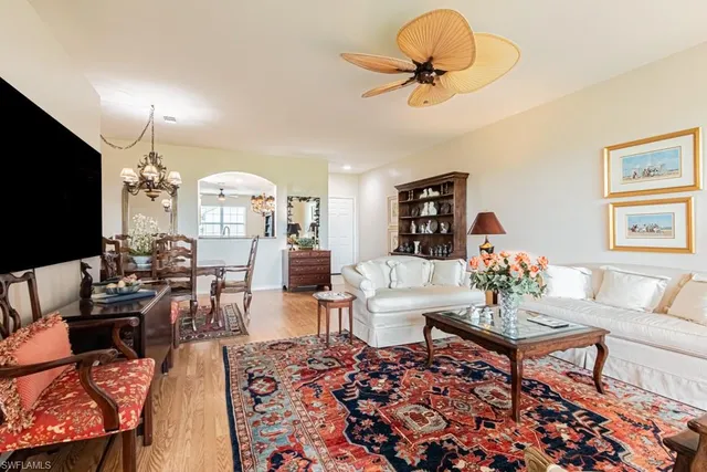a living room with furniture a chandelier and a flat screen tv