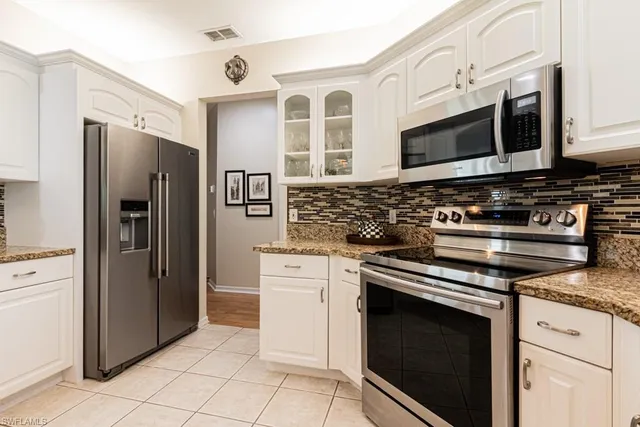 a kitchen with stainless steel appliances granite countertop a stove microwave and refrigerator