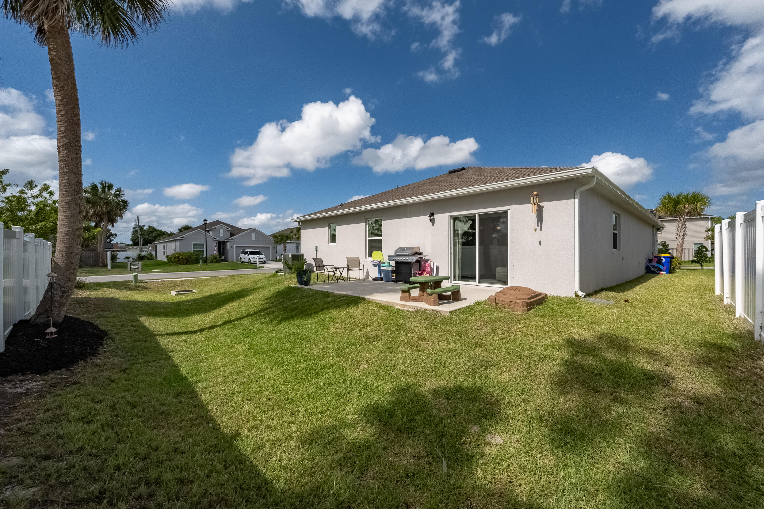 953 Edensor Lane Rockledge, FL 32955 - Photo 31 of 39 a view of a white house with a swimming pool and a yard
