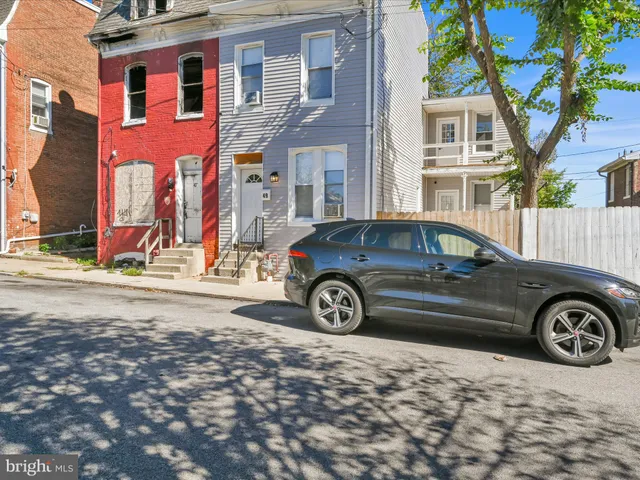 a car parked in front of a brick house