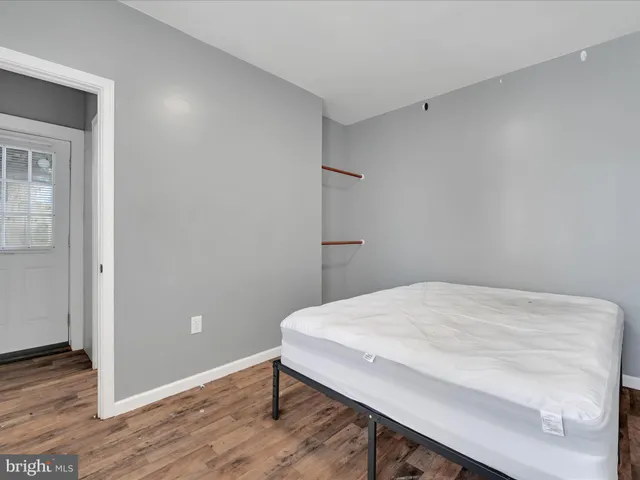 a room with a bed and wooden floor