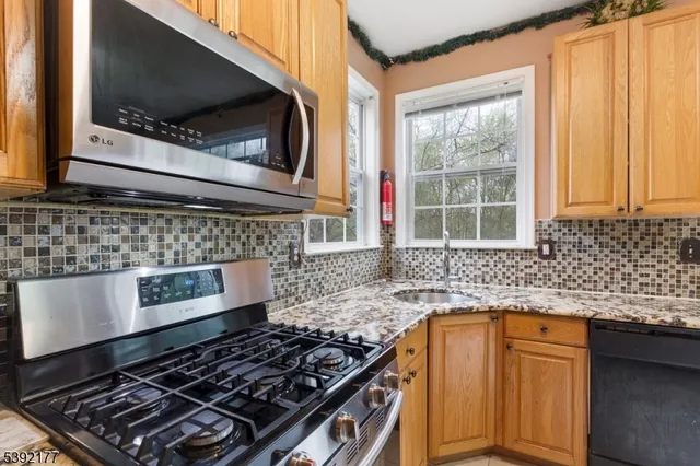 a kitchen with granite countertop a stove sink and microwave