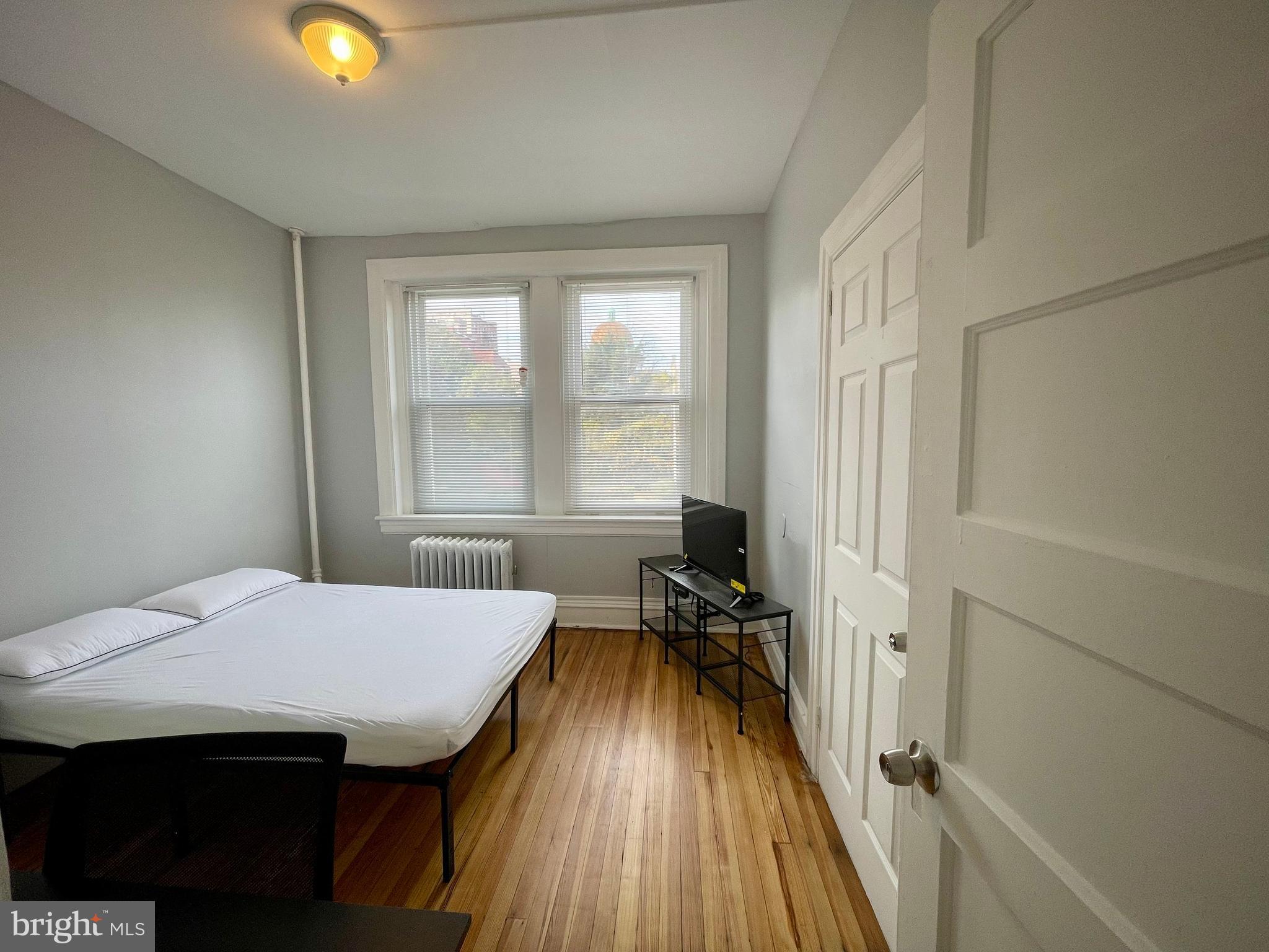 307 Dolphin Street, Unit 2B Baltimore, MD 21201 - Photo 13 of 17 a view of a bedroom with a bed and wooden floor