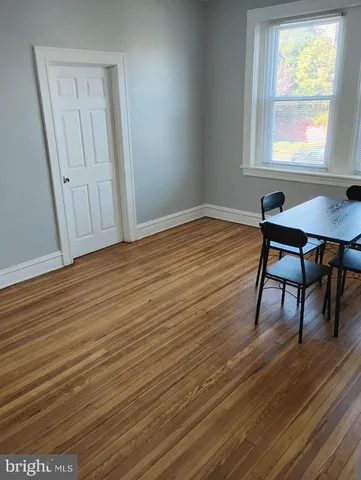 a view of a room with wooden floor and a window