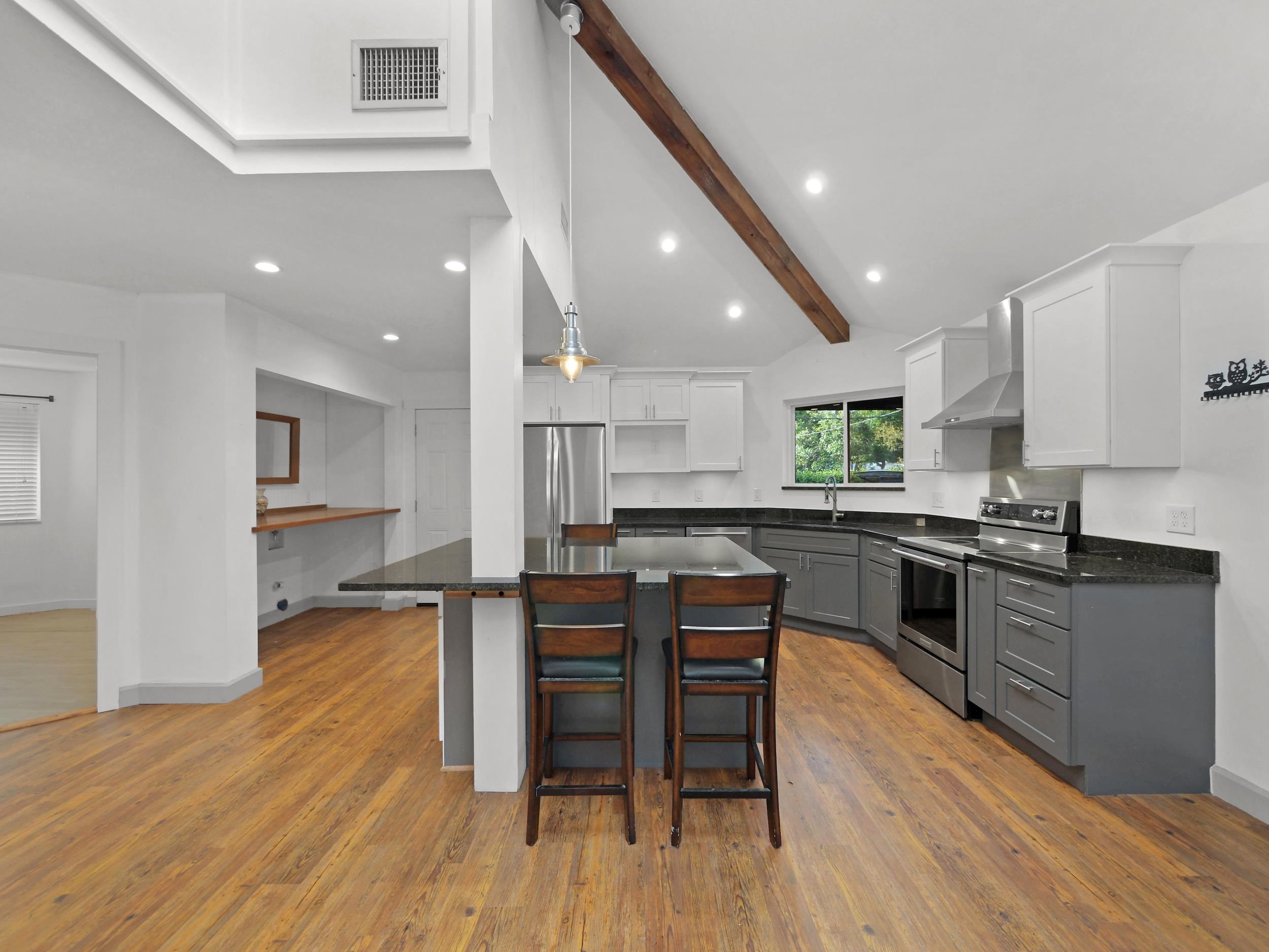 369 Orchis Road St. Augustine, FL 32086 - Photo 12 of 41 a kitchen with stainless steel appliances kitchen island granite countertop wooden floors and wooden cabinets