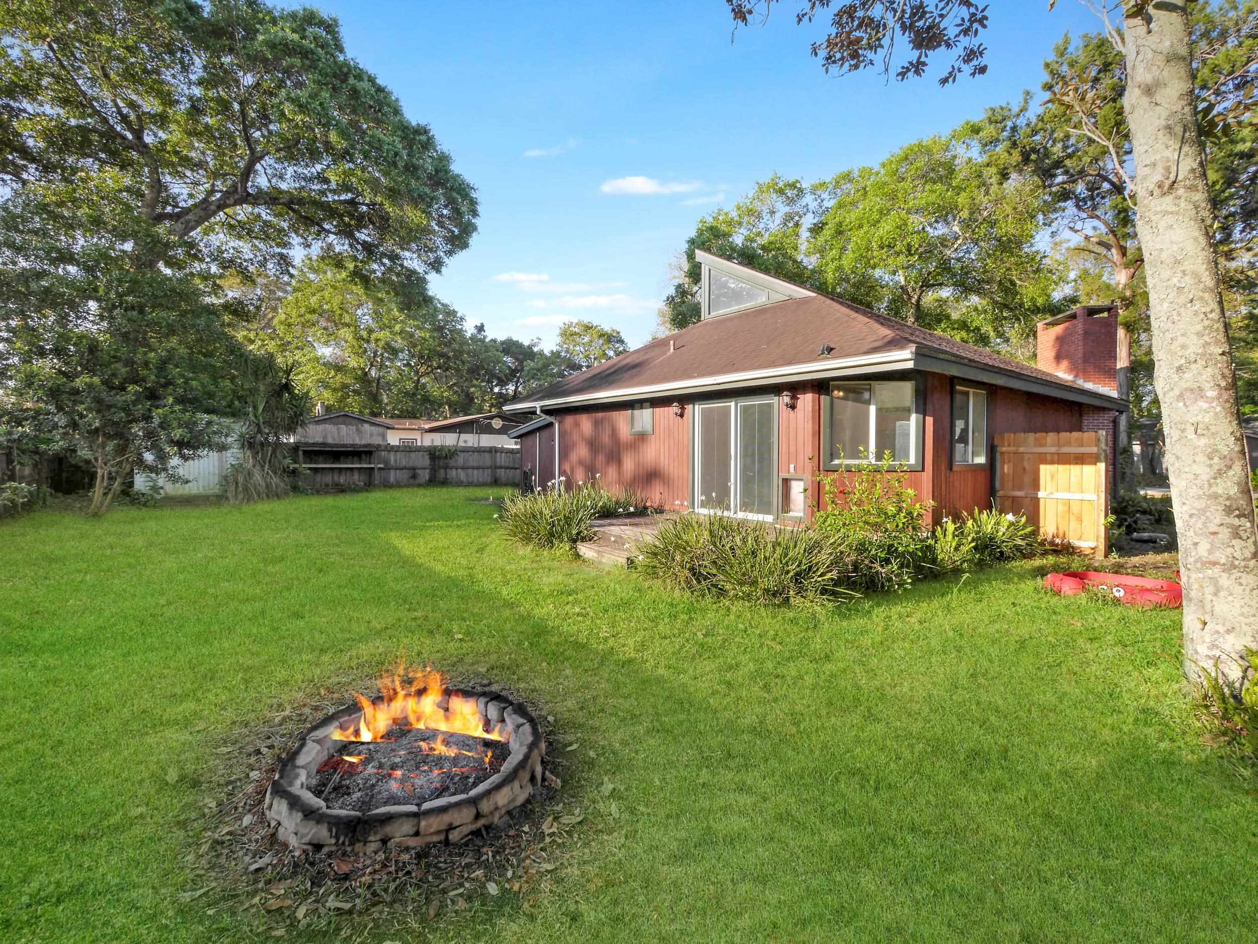 369 Orchis Road St. Augustine, FL 32086 - Photo 27 of 41 a view of a backyard with table and chairs and a fire pit