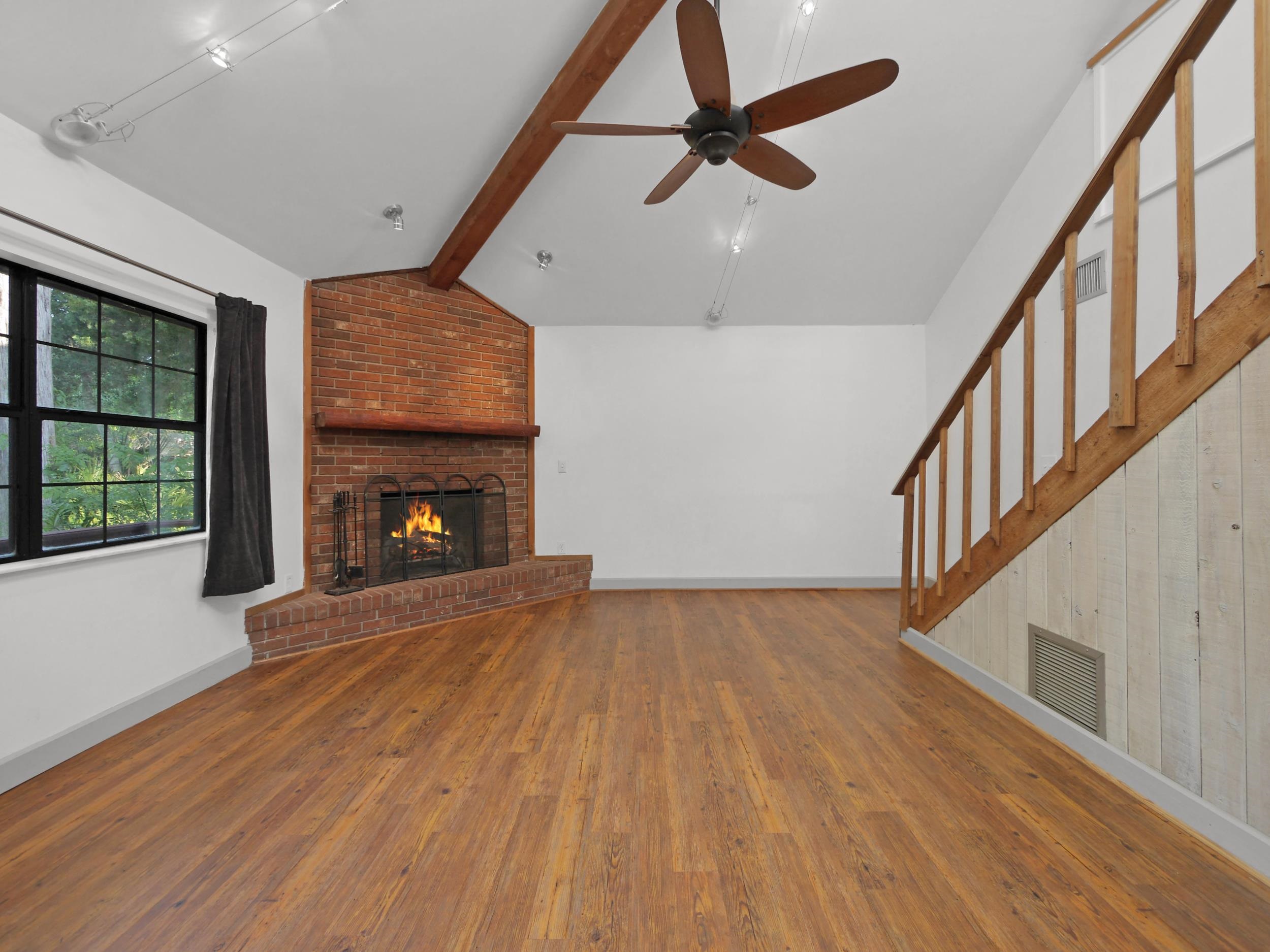 369 Orchis Road St. Augustine, FL 32086 - Photo 6 of 41 a view of an empty room with wooden floor fireplace and a window