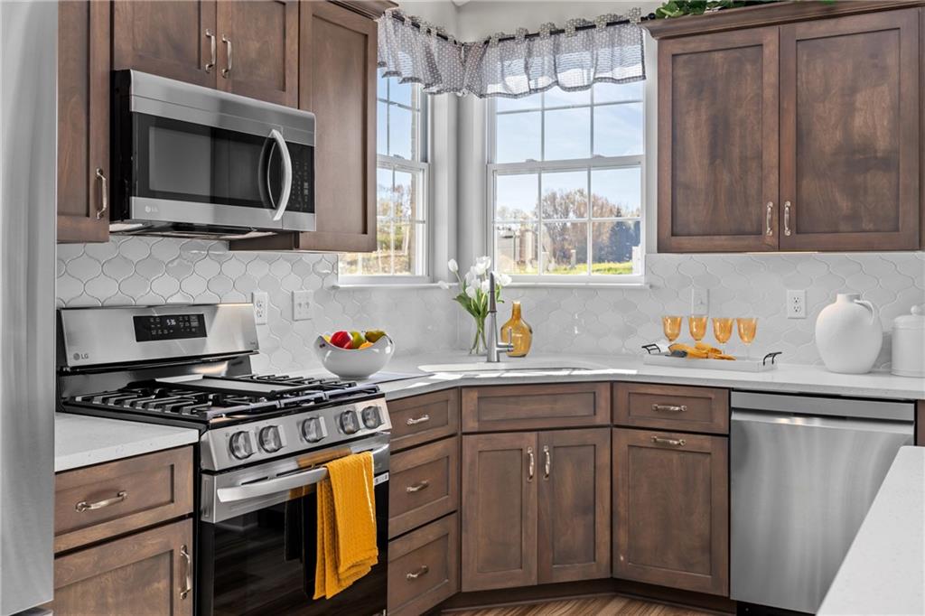 106 Independence Drive Cabot, PA 16023 - Photo 13 of 32 a kitchen with stainless steel appliances a stove sink microwave and cabinets