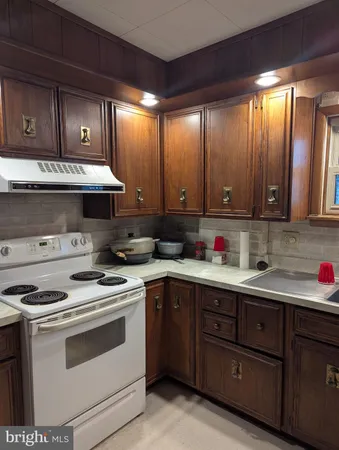 a kitchen with stainless steel appliances granite countertop wooden cabinets and a stove top oven