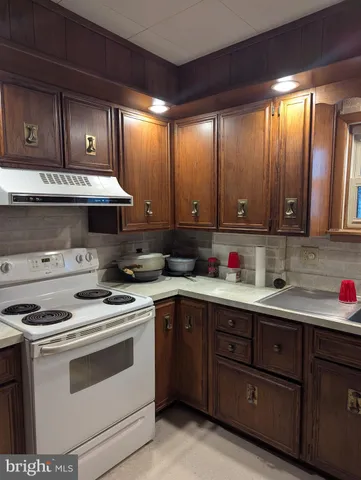 a kitchen with stainless steel appliances granite countertop wooden cabinets and a stove top oven