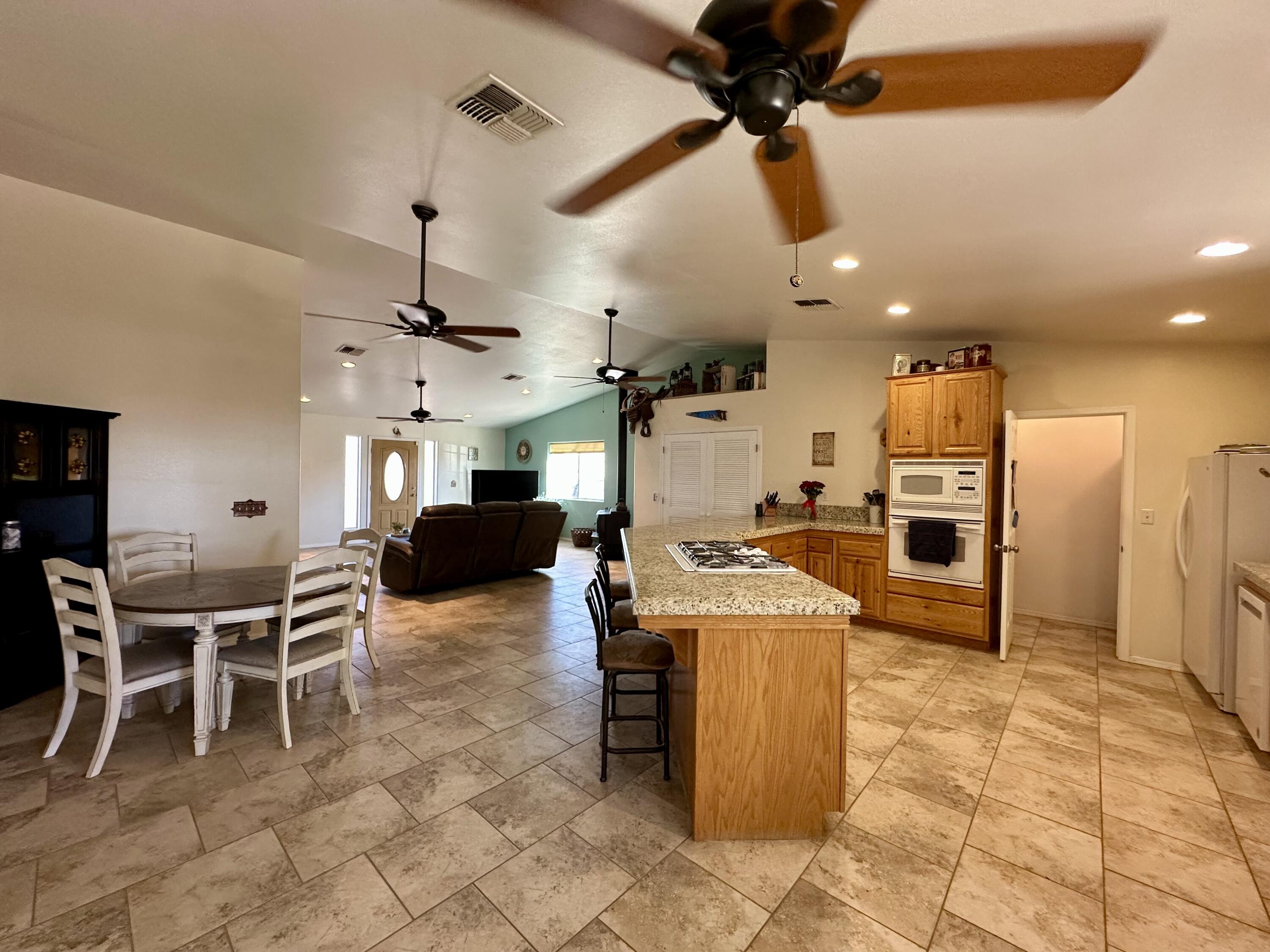 1731 Riviera Drive Blythe, CA 92225 - Photo 11 of 36 a kitchen with stainless steel appliances kitchen island granite countertop a table chairs and a refrigerator