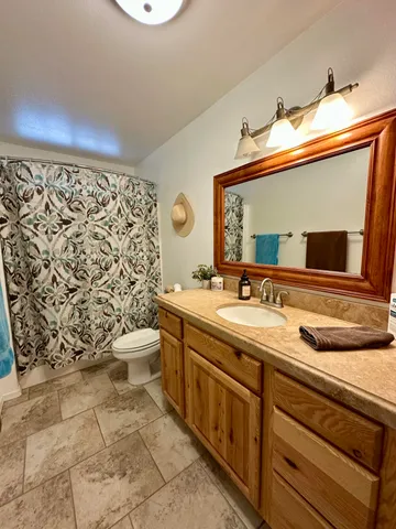 a bathroom with a granite countertop sink mirror vanity and toilet