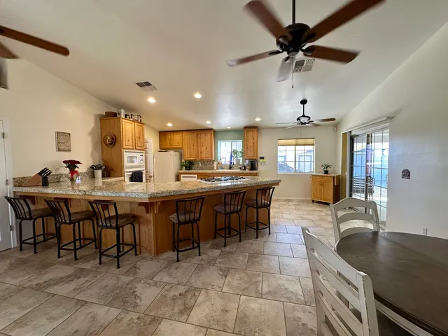 a large kitchen with kitchen island a dining table chairs and a sink
