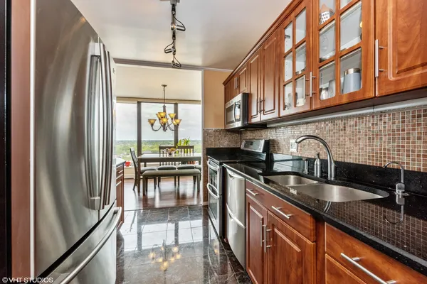 a kitchen with stainless steel appliances granite countertop a sink stove and cabinets