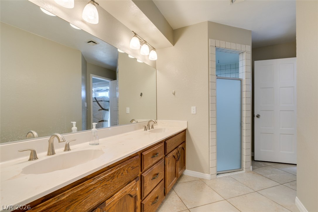 892 North Hollywood Boulevard Las Vegas, NV 89110 - Photo 41 of 81 This primary bathroom offers dual sinks, a large mirror, and tiled flooring.