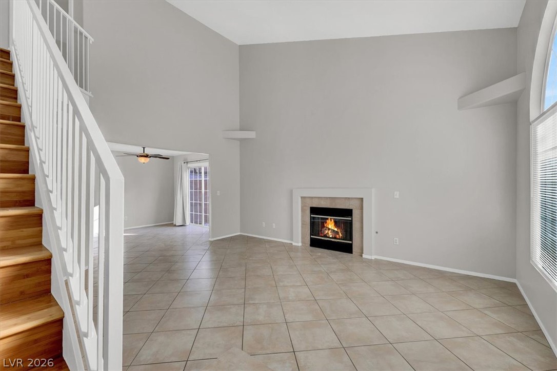 10148 Tree Bark Street Las Vegas, NV 89183 - Photo 4 of 37 A spacious living area with soaring ceilings features a cozy fireplace and convenient access to outdoor space.