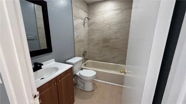 a bathroom with a sink a toilet a mirror and shower