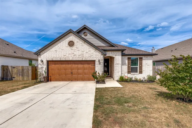 a front view of a house with yard outdoor seating and garage