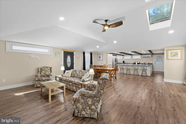 a dining room with furniture a chandelier and wooden floor