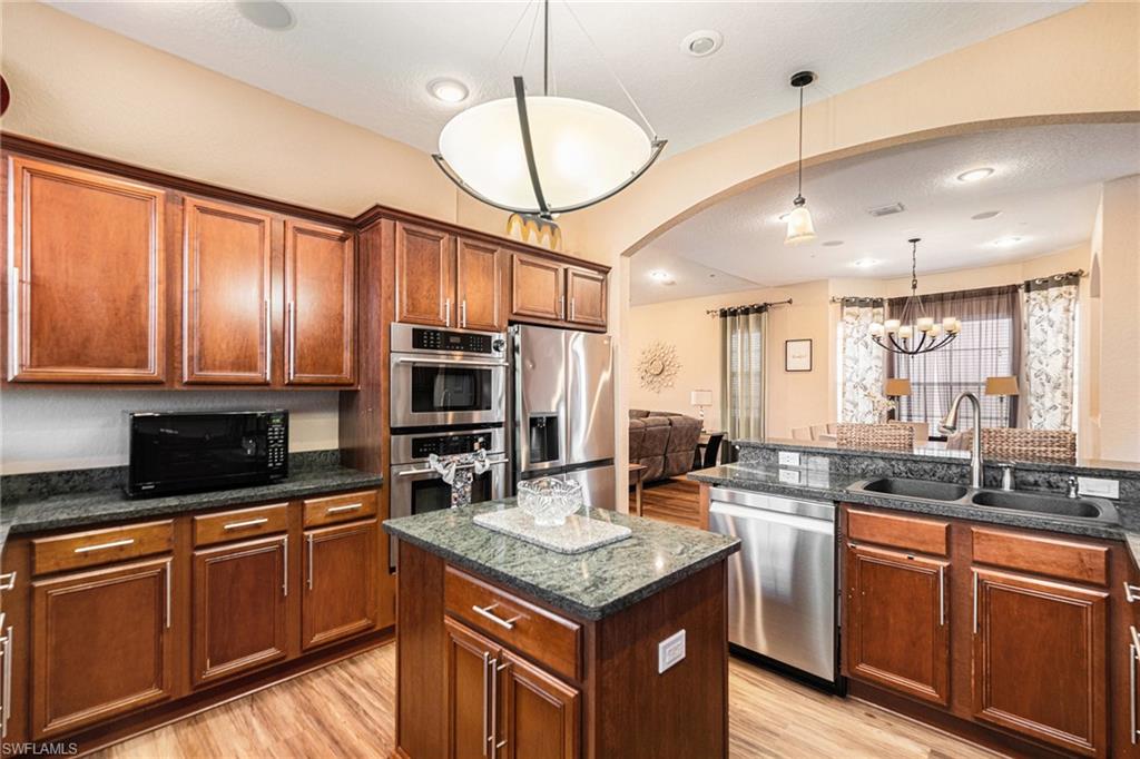 1316 Apollo Beach Boulevard South Apollo Beach, FL 33572 - Photo 15 of 47 a kitchen with granite countertop stainless steel appliances a sink stove and cabinets