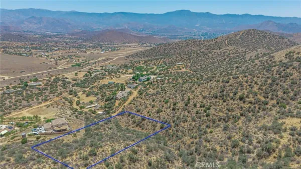 a view of a dry yard with mountains in the background