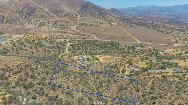 a view of a dry yard with wooden fence