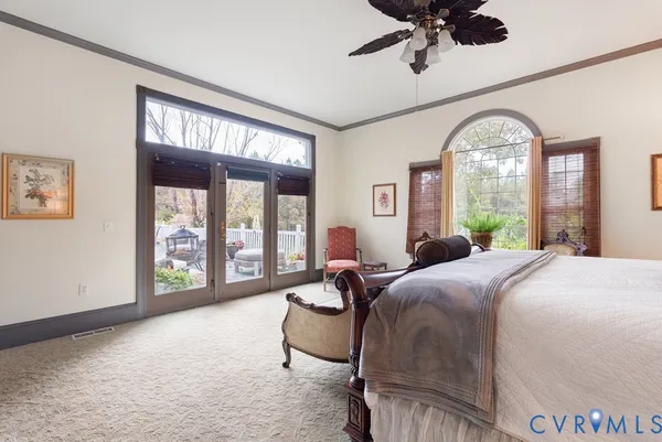 a bedroom with a large bed and a chandelier