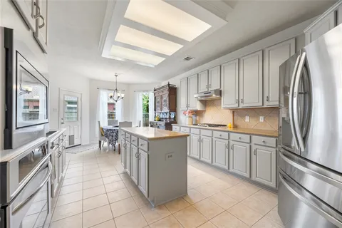 a kitchen with stainless steel appliances granite countertop a refrigerator sink and cabinets