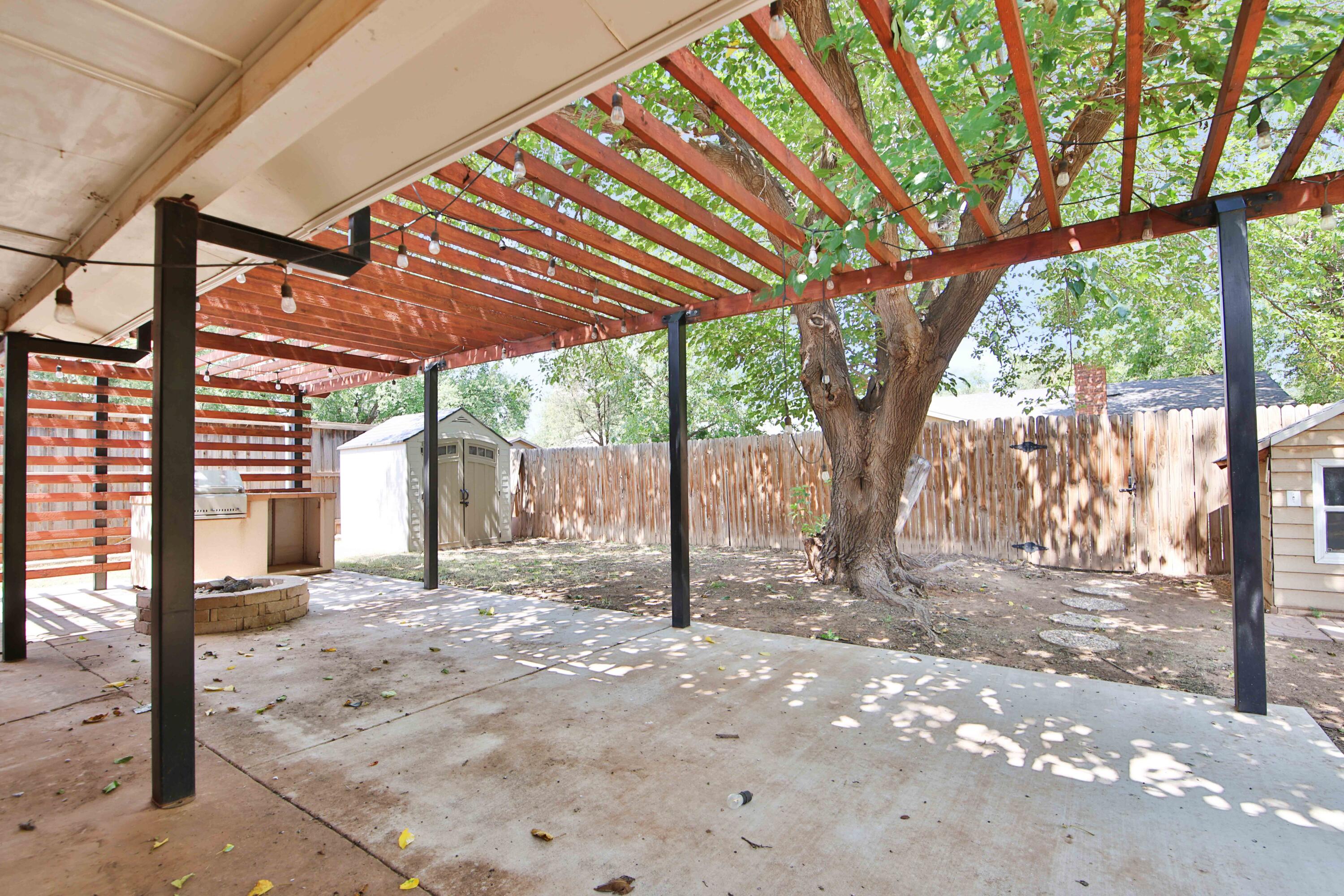 4818 73rd Street Lubbock, TX 79424 - Photo 9 of 31 a view of a backyard with wooden fence and large trees