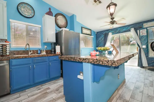 a kitchen with stainless steel appliances granite countertop a stove a sink dishwasher and a microwave oven with cabinets