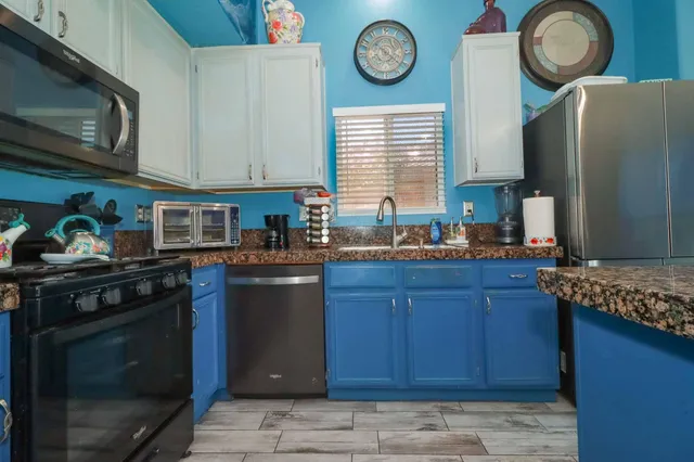 a kitchen with stainless steel appliances granite countertop a refrigerator stove and sink