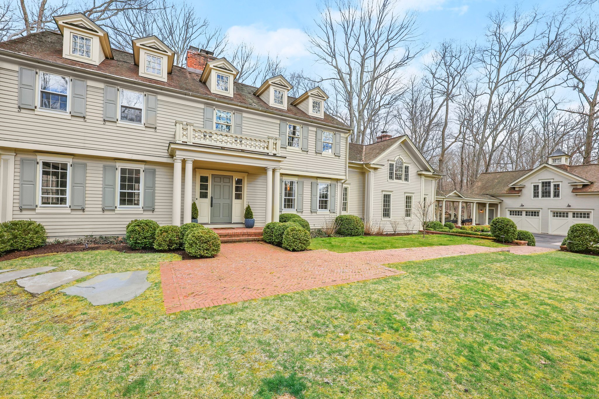a view of a brick house with a big yard and large trees