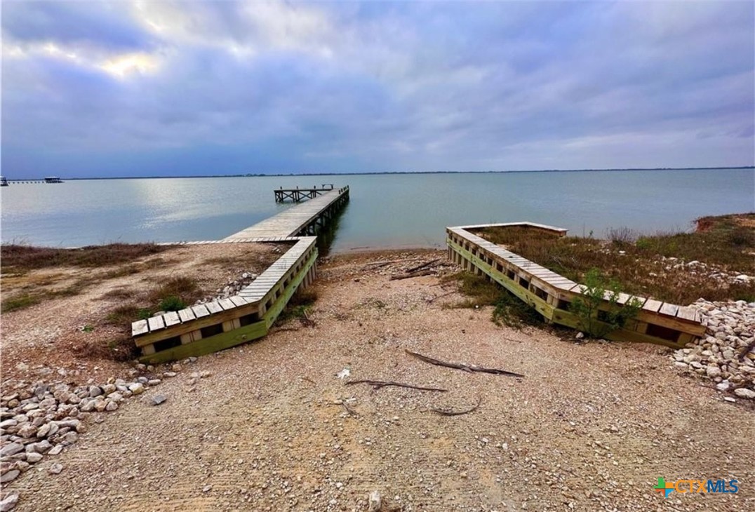 61 Falcon Way Palacios, TX 77465 - Photo 5 of 22 a wooden bench sitting in the middle of a beach