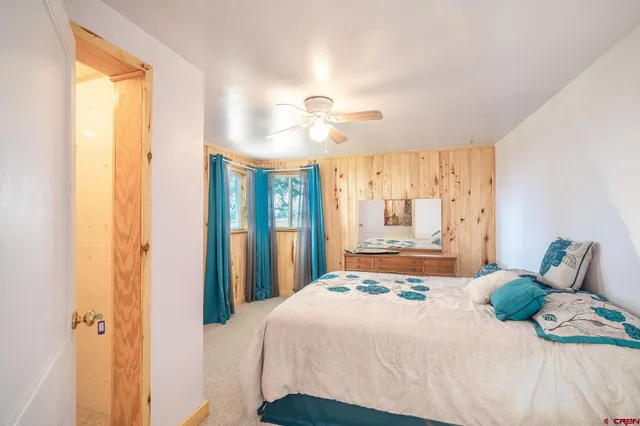 a spacious bedroom with a bed a table and large mirror