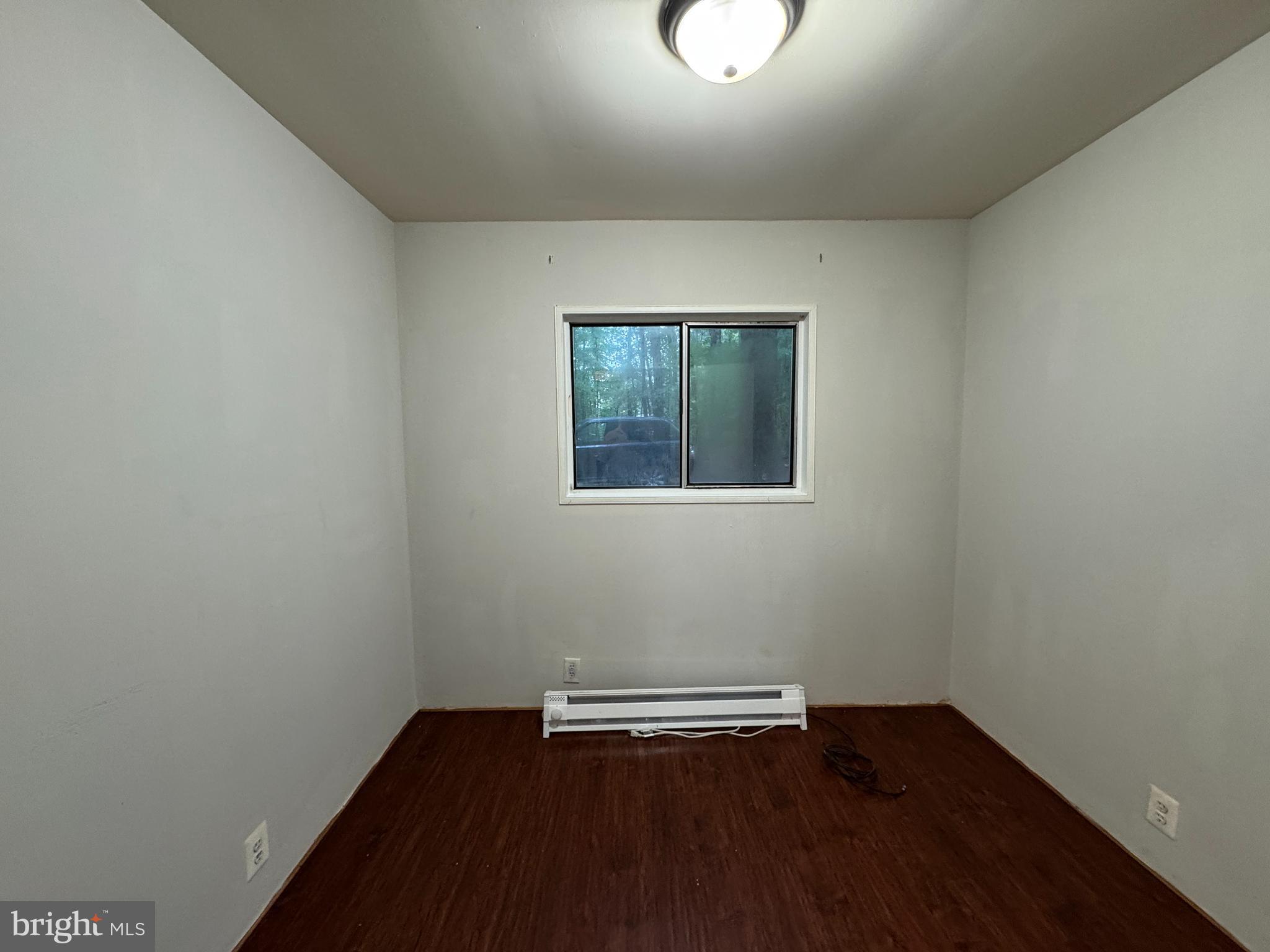 19086 Carlyle Street Ruther Glen, VA 22546 - Photo 13 of 19 an empty room with wooden floor and windows