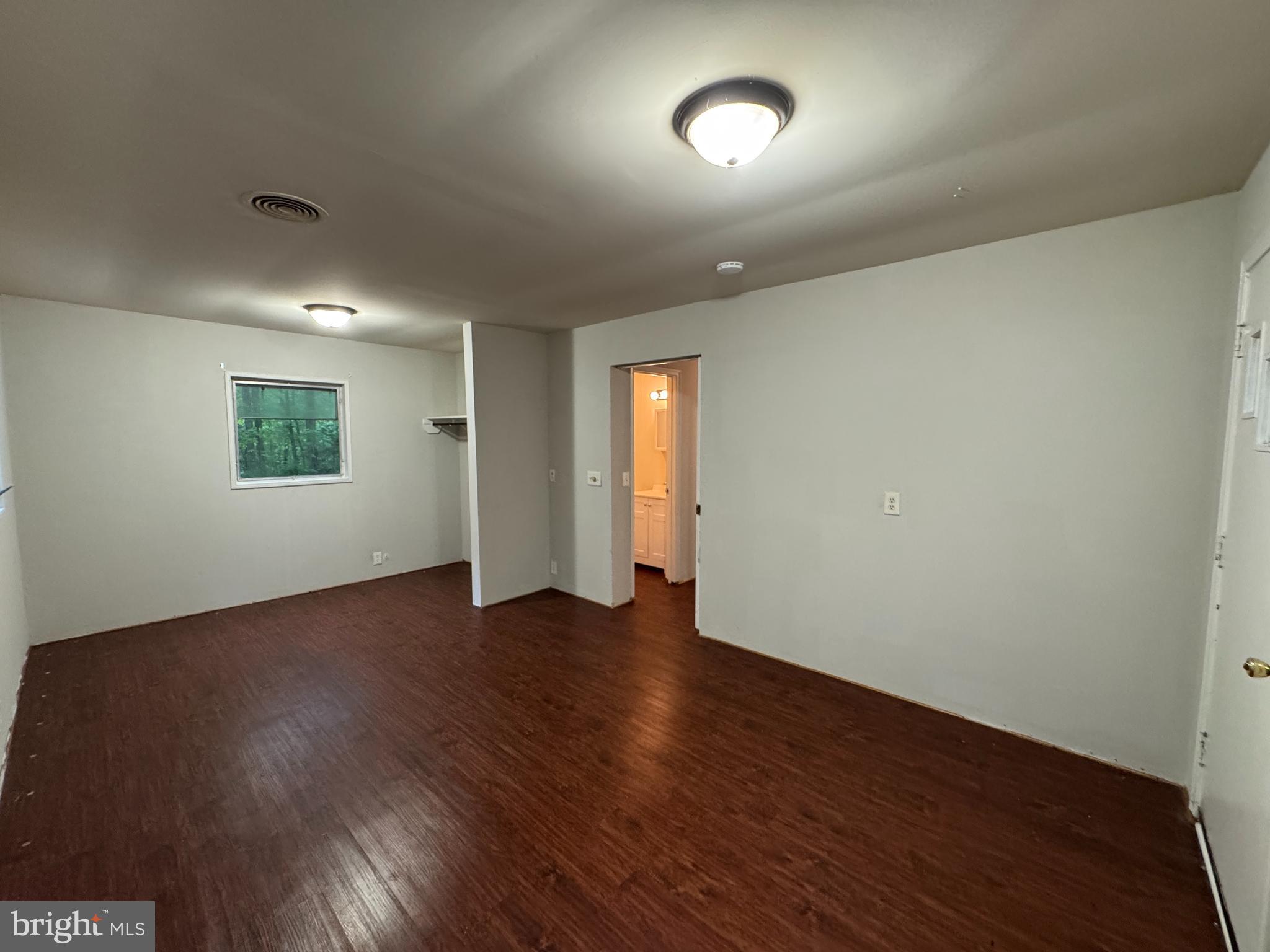 19086 Carlyle Street Ruther Glen, VA 22546 - Photo 10 of 19 an empty room with wooden floor and windows
