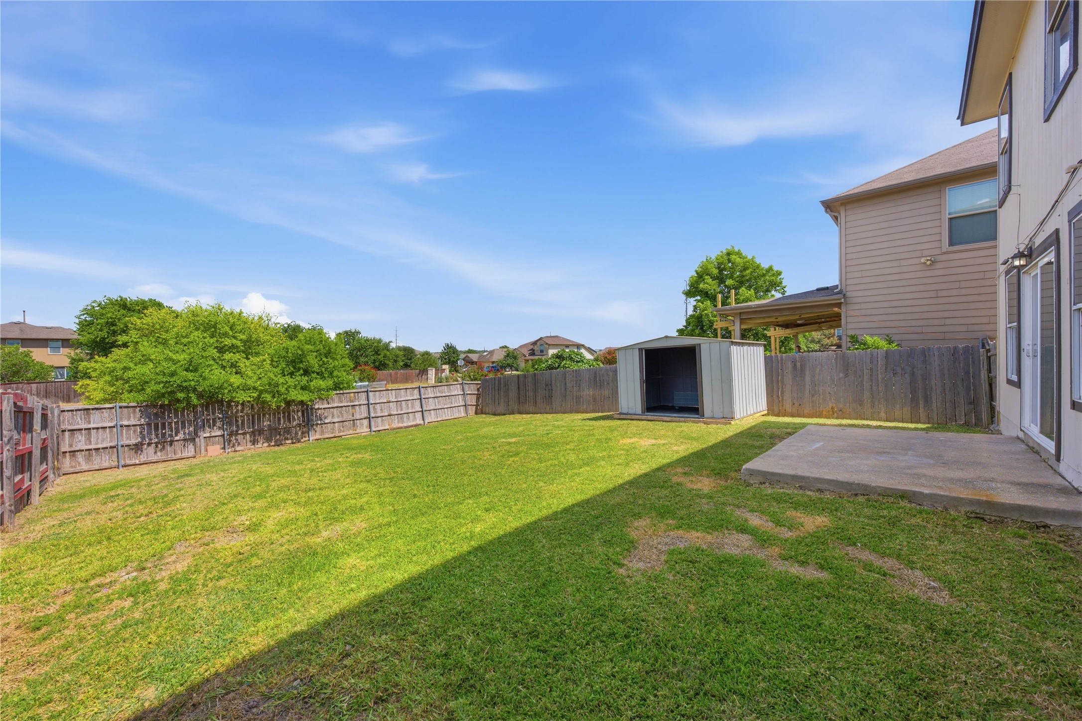 6917 Panda Royle Drive Del Valle, TX 78617 - Photo 22 of 23 A spacious backyard with a utility shed offers ample room for outdoor activities.