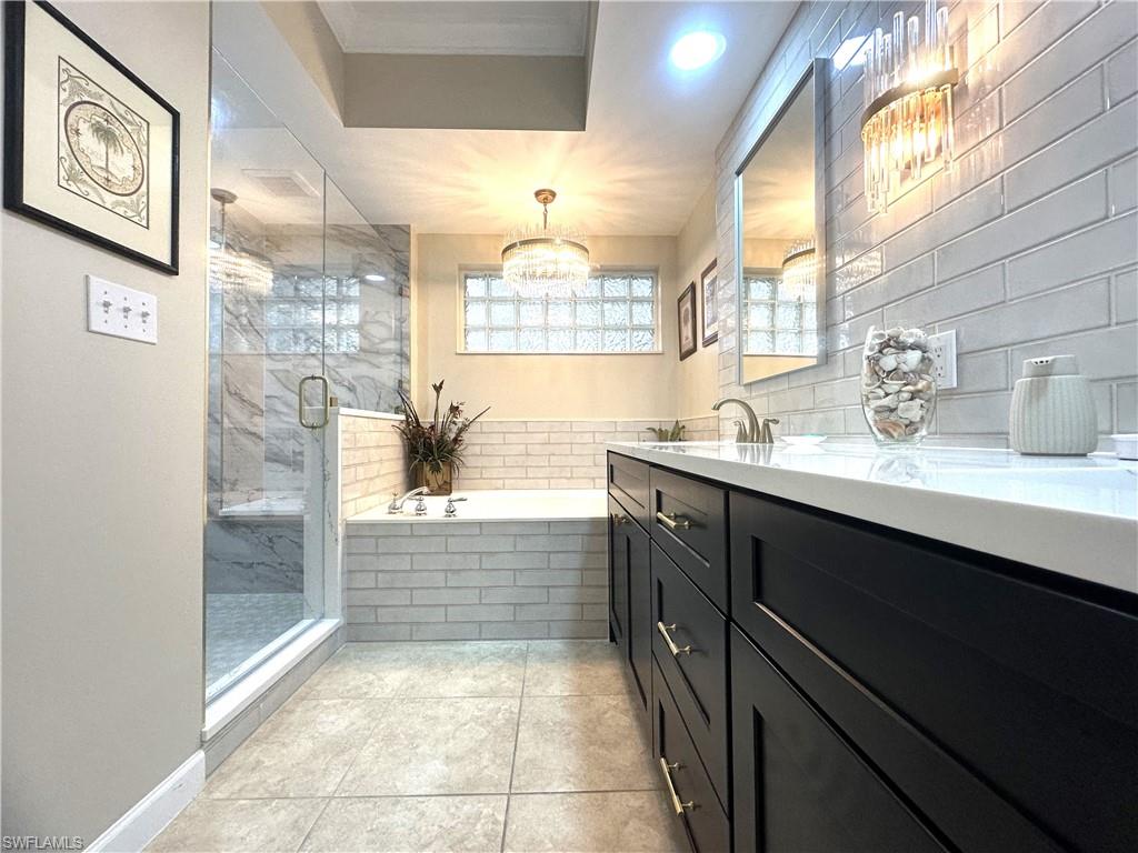 325 Dunes Boulevard, Unit 306 Naples, FL 34110 - Photo 22 of 40 a bathroom with a bathtub sink and mirror