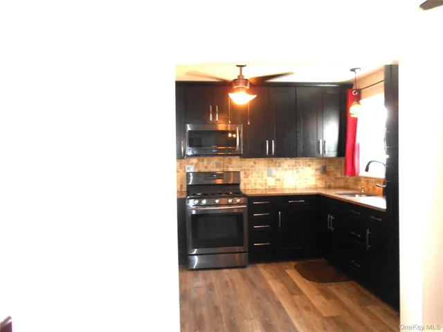 a kitchen with stainless steel appliances granite countertop a sink and a stove