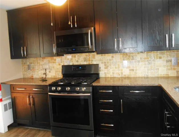 a kitchen with granite countertop stainless steel appliances a sink dishwasher and cabinets