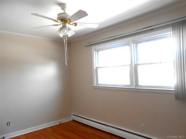 an empty room with a window and a fan