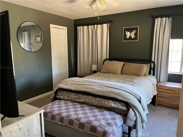 a bedroom with a bed a mirror and window