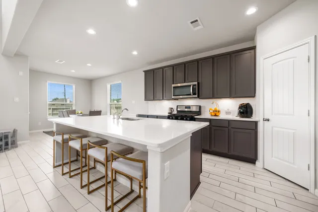 a kitchen with a sink a microwave and cabinets